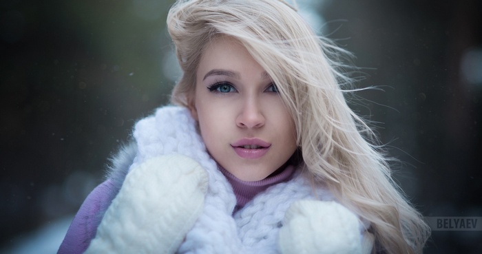 Woman with blonde hair and blue eyes in winter clothing
