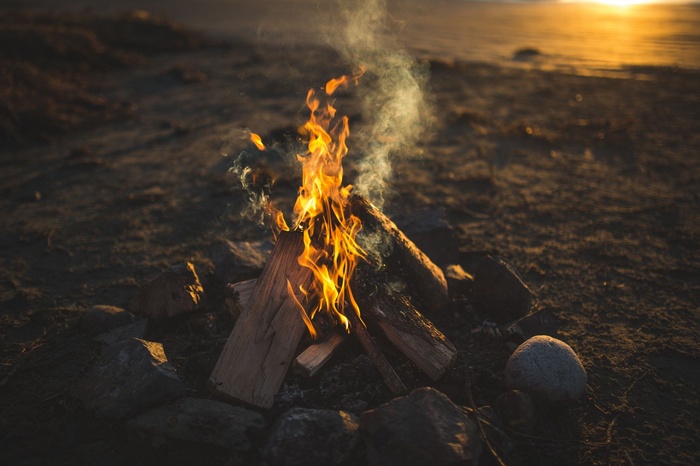 Campfire burning on a beach at sunset