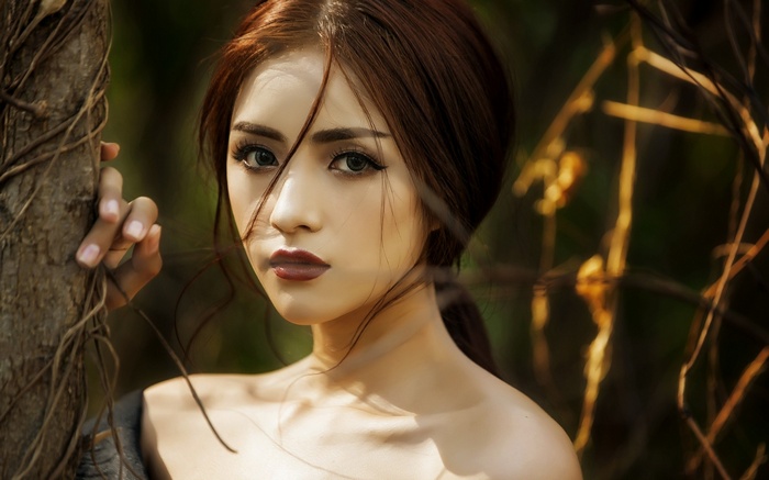 Asian woman with brown hair and green eyes outdoors