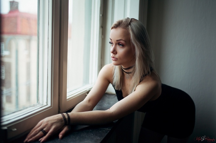 Woman with blonde hair looking out a window