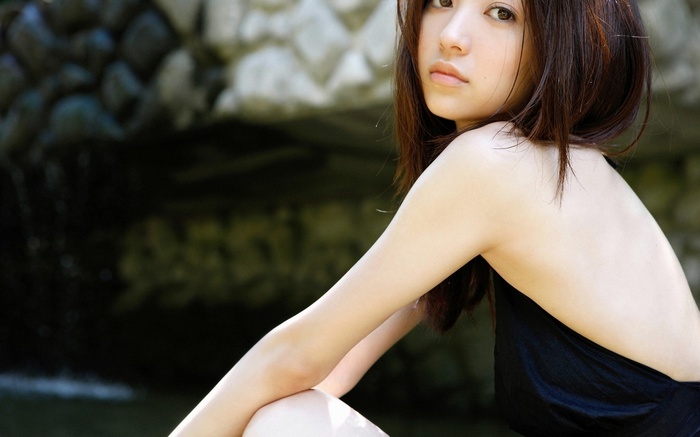 Rina Aizawa posing outdoors near rocks and water