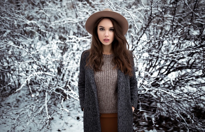 Woman in hat and coat in snowy forest