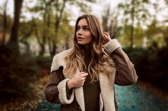 Woman in a shearling coat outdoors in autumn