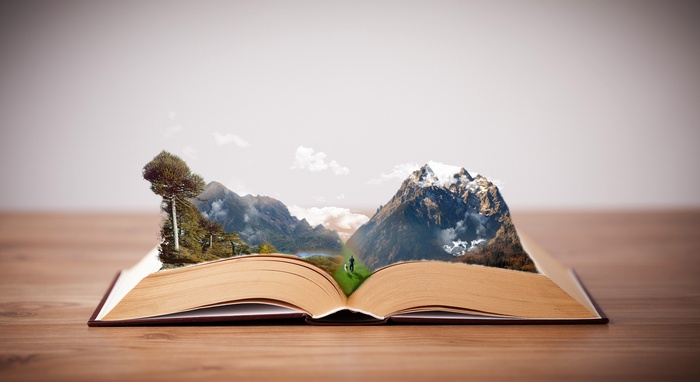 Open book with mountain landscape emerging