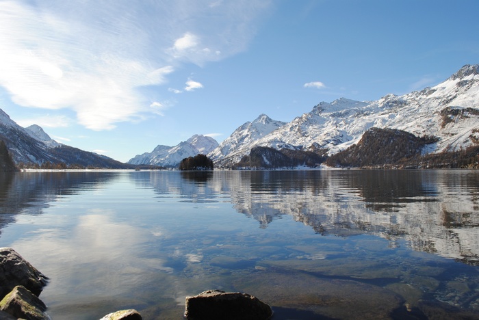 Snow-capped mountains reflected in a clear lake in Switzerland