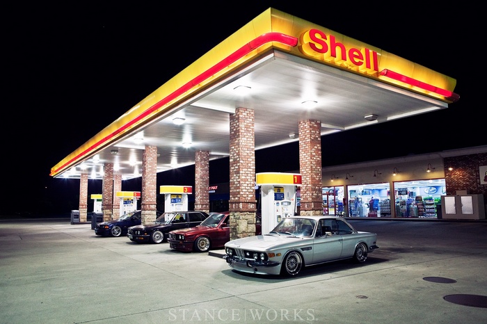 BMW cars at a Shell gas station at night
