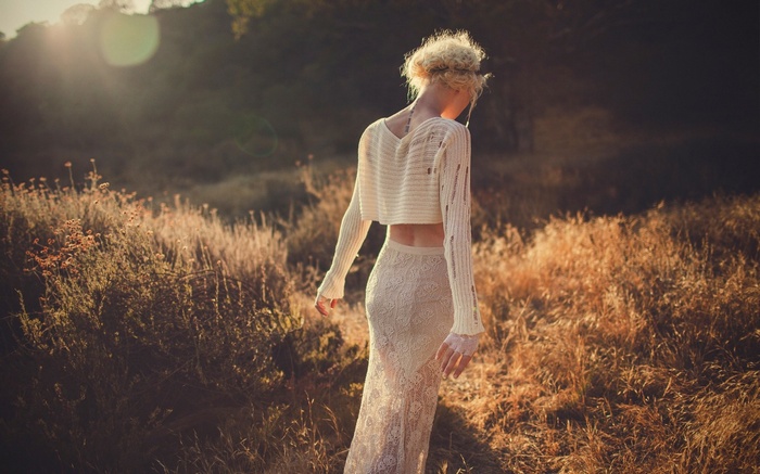 Woman in a white crop top and lace skirt outdoors