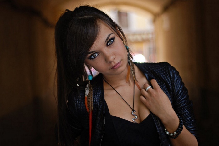 Woman with feather earrings in a tunnel