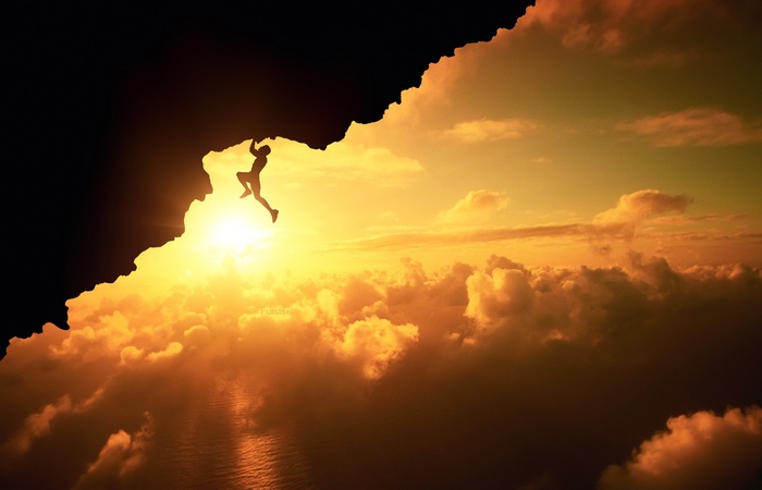 Silhouette of a climber on a cliff at sunset
