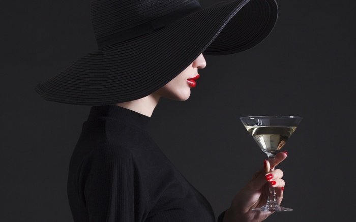 Woman in black hat holding a martini