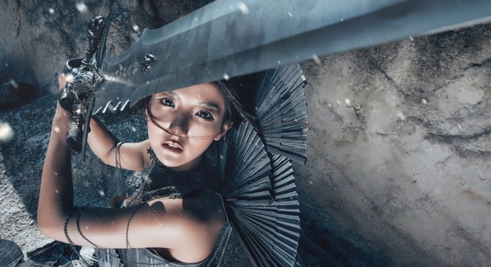Asian woman holding Frostmourne sword