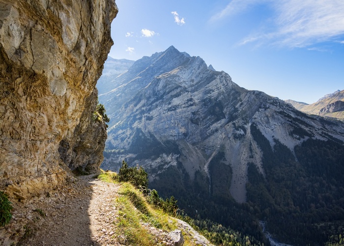 Mountain path along a cliff face with a valley view
