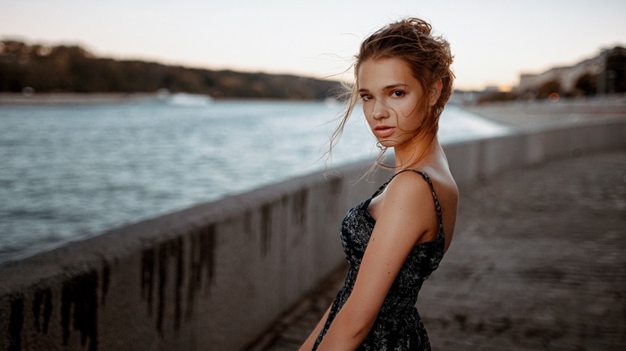 Woman with auburn hair in a dress by the water