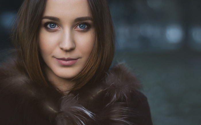 Woman with blue eyes wearing a fur coat