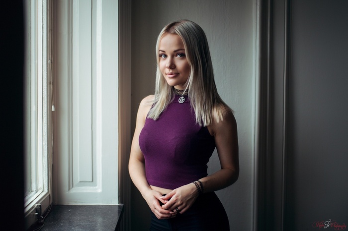Woman with blonde hair wearing a purple top