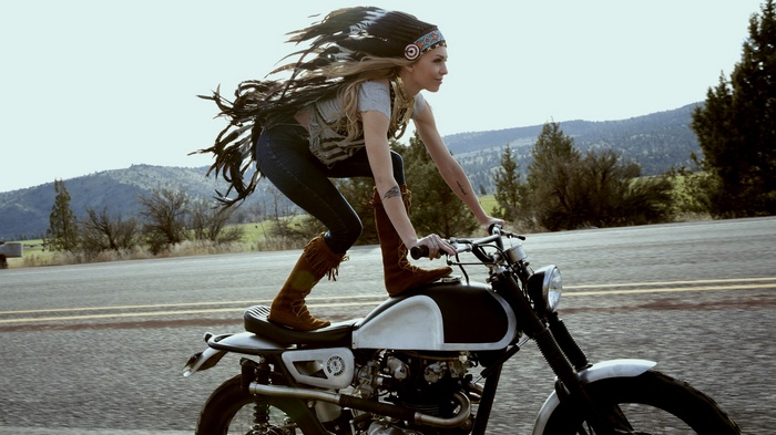 Woman in Native American Headdress Riding a Motorcycle