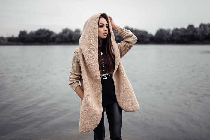 Woman in hooded sweater by the river