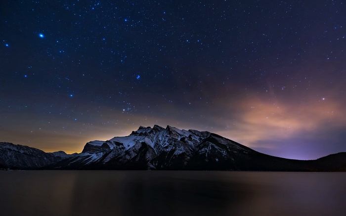 Snowy mountains under a starry night sky