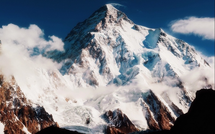 K2 mountain peak with clouds and blue sky