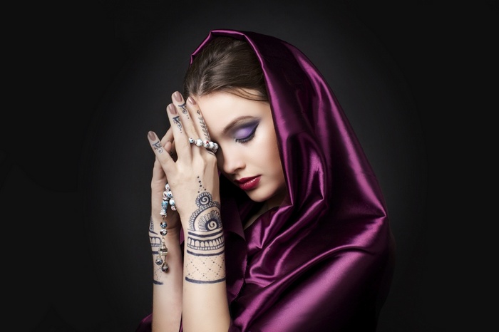 Woman with purple headscarf and henna tattoos