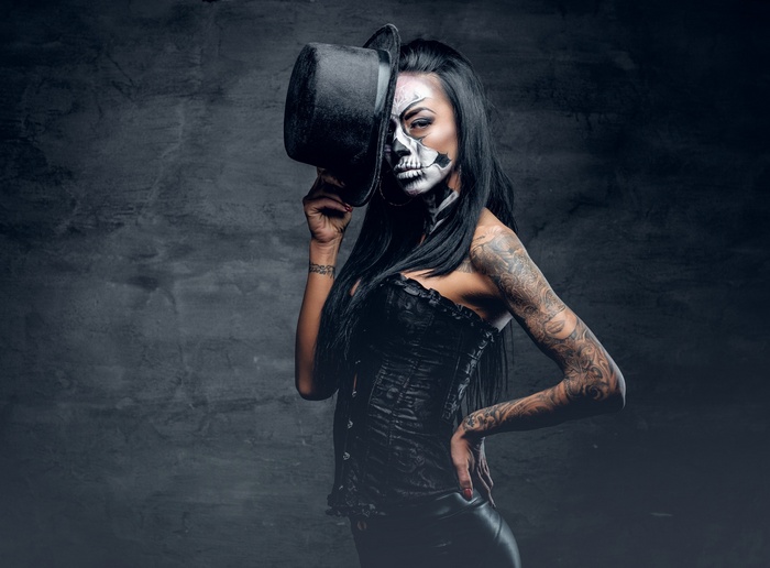 Woman with skull makeup and top hat