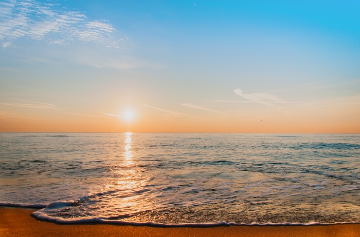 Sunrise over the ocean with a sandy beach