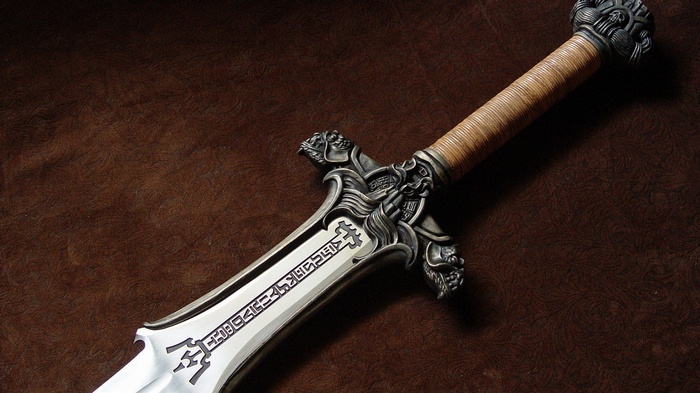 Conan the Barbarian's ornate sword on a brown surface