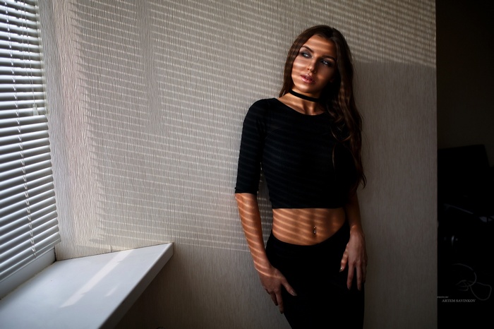 Yanina Vorozheikina in black clothing by a window