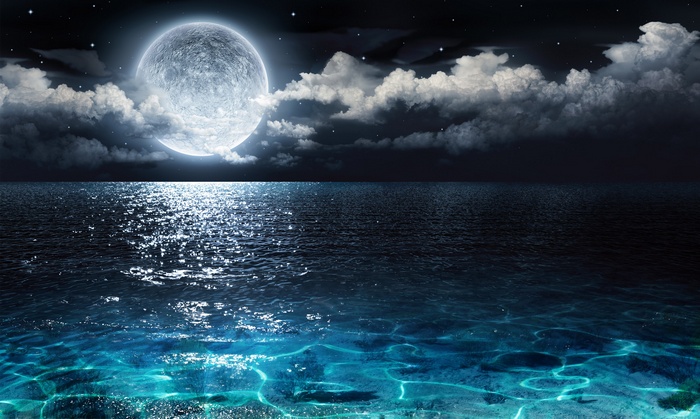 Full moon over the ocean at night