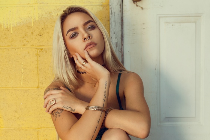 Woman with blonde hair and tattoos wearing jewelry