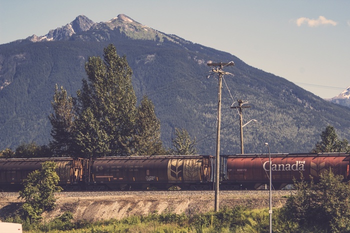 Train passing by mountains in Canada