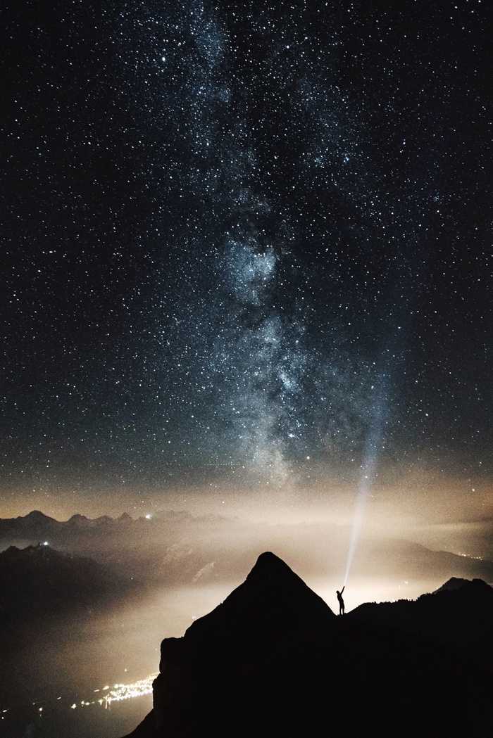 Person with flashlight under the Milky Way