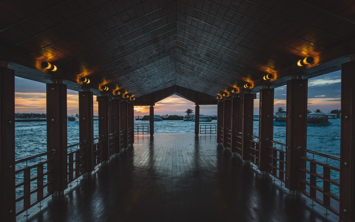 Covered walkway over the water at sunset