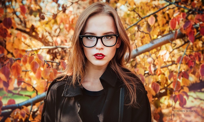 Woman with glasses and red lipstick in autumn
