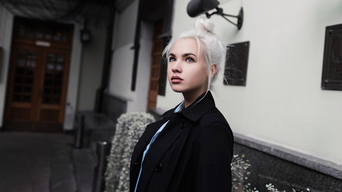 Woman with white hair in a black coat
