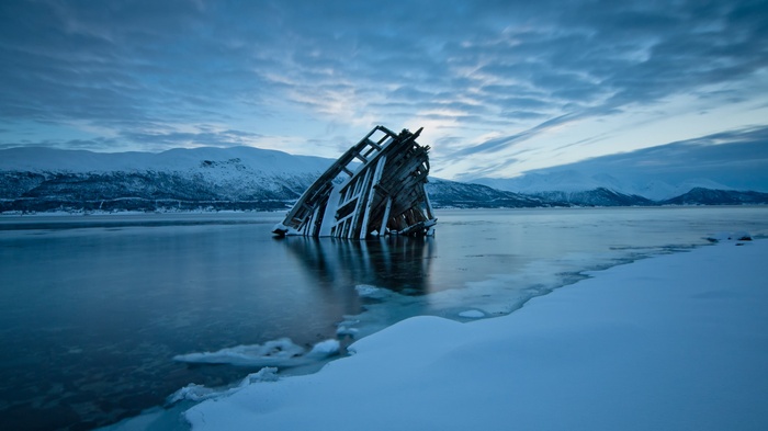Shipwreck in a frozen Norwegian landscape at dusk