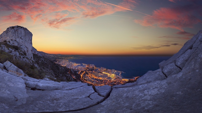 Monaco cityscape at sunset from a rocky viewpoint