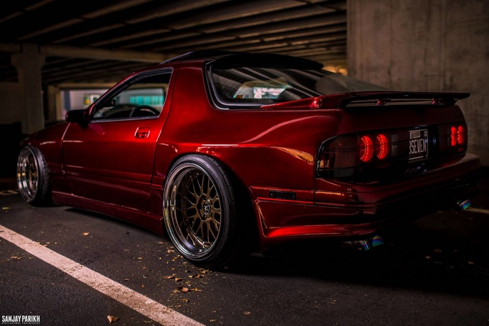 Red Mazda RX-7 with custom wheels