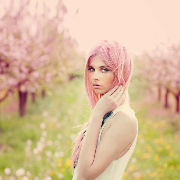 Woman with pink hair in a field of flowers
