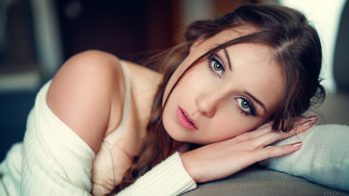 Woman with green eyes resting her head on her hand