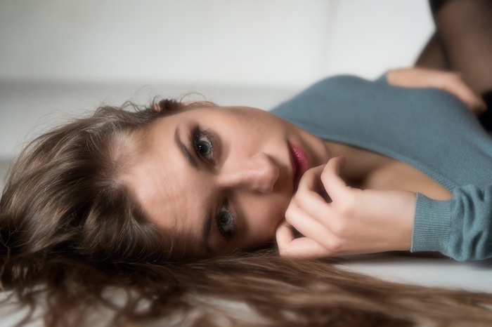 Woman lying down with hand on face