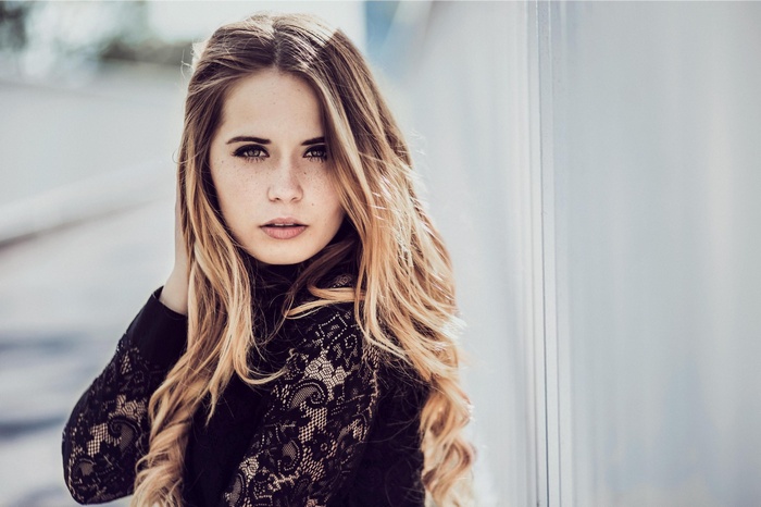 Woman with blonde hair wearing a black lace top