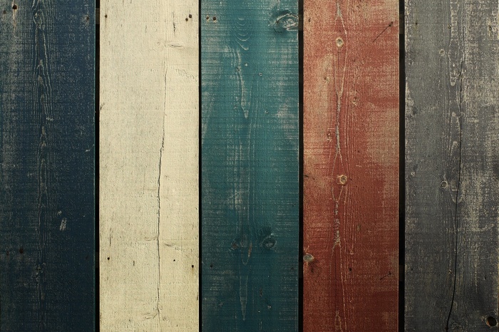 Weathered wooden planks in blue, white, teal, red, and gray