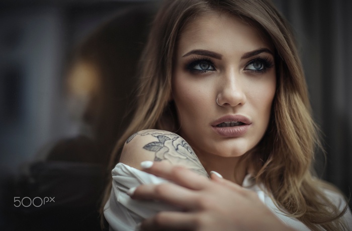 Portrait of a blonde woman with tattoos and nose ring