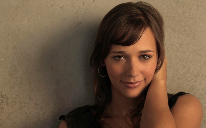 Rashida Jones smiles against a textured wall