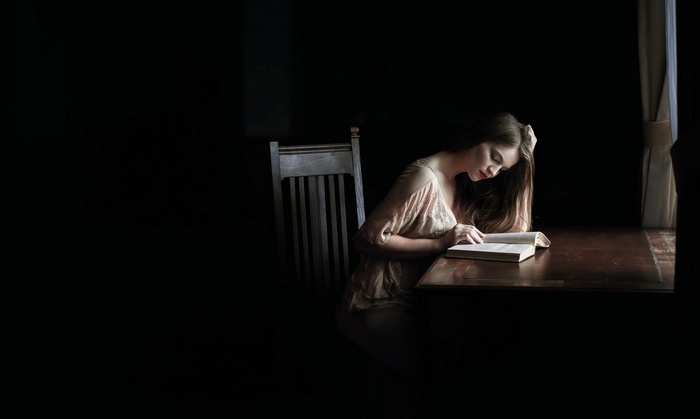 Woman reading a book at a table