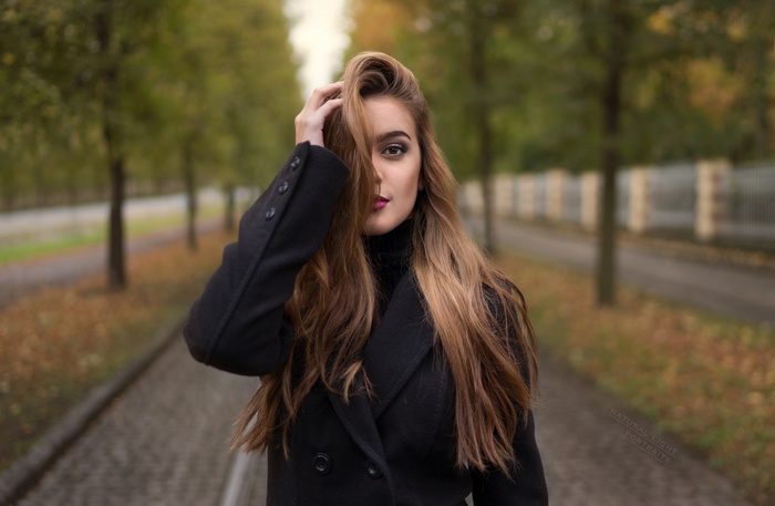 Woman with long brown hair in a black coat