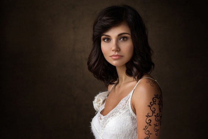 Woman with dark hair and tattoo