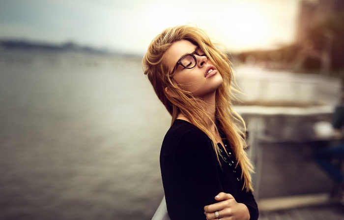 Woman with blonde hair and glasses outdoors