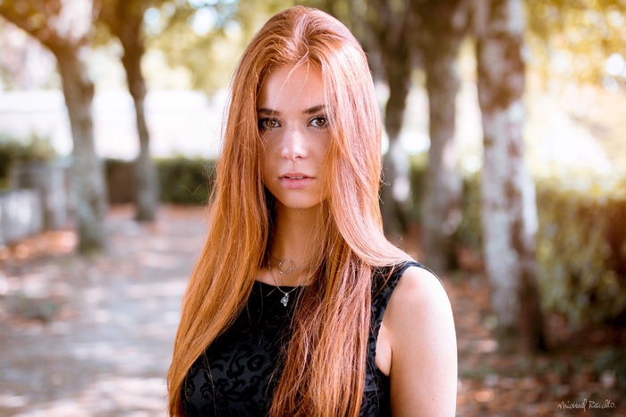 Redhead woman with brown eyes in black clothing outdoors